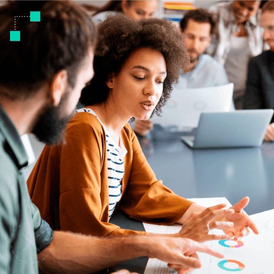 Two employees discussing company plans at a meeting